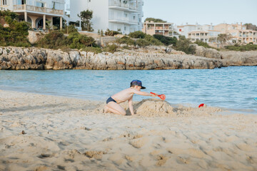 Child plays in the sand on the beach. With a child by the sea 