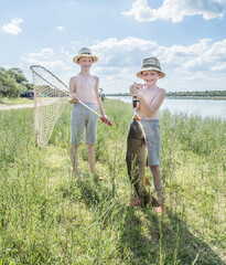 Niños pescando un gran pez en el río