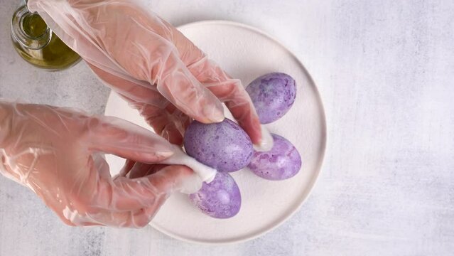 Coloring Easter eggs with carcade tea. Olive oil gives shine to eggs. Close-up.
