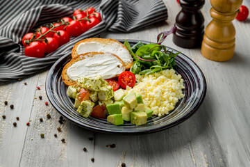scramble with mozarella and avocado on grey wooden table