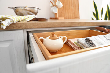 Fototapeta na wymiar Closeup view of opened drawer with utensils in kitchen