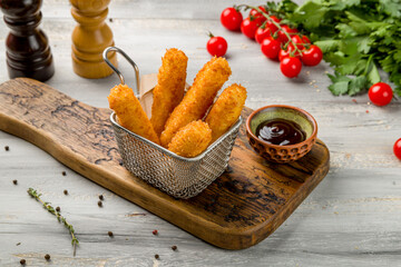 fried Cheese sticks on the board on grey table