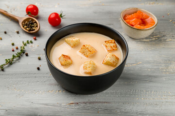 salmon cream soup on black bowl on grey wooden table