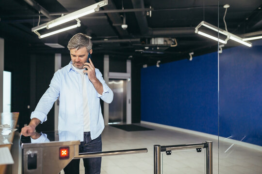 Portrait of a successful businessman with a beard, a man happily enters the office with a turnstile on a magnetic card