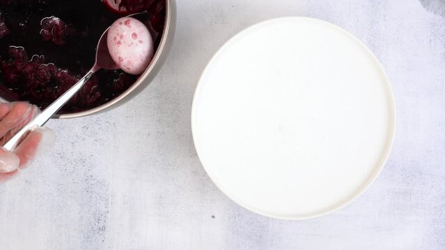 Coloring Easter eggs with carcade tea from hibiscus flowers. Egg becomes purple.