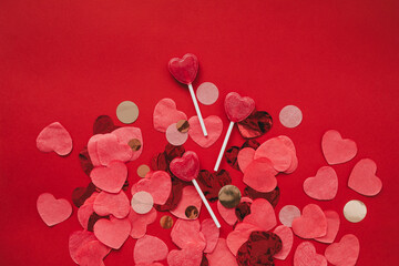 Heart shaped confetti on red background. Valentine's Day celebration.