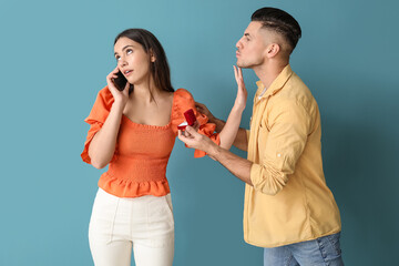 Busy young woman rejecting marriage proposal on blue background