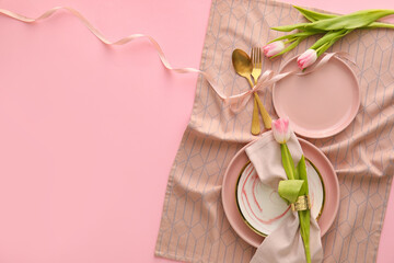 Stylish table setting with tulip flowers on pink background