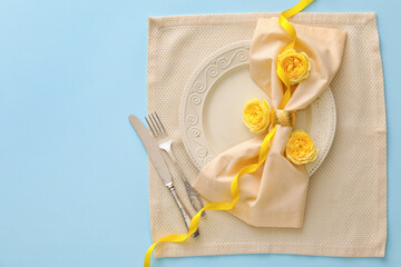 Stylish table setting with flowers on blue background