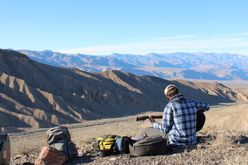 person with guitar in mountains