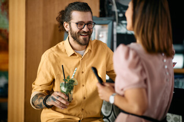 Young man has fun while talking to his girlfriend during their date in bar.