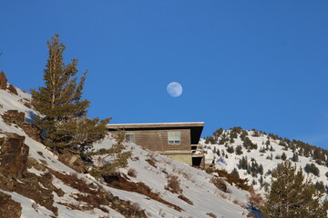 moon over house in the mountains