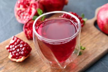 Glass of delicious pomegranate juice on table
