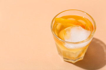 Glass of delicious Old Fashioned Cocktail on beige background