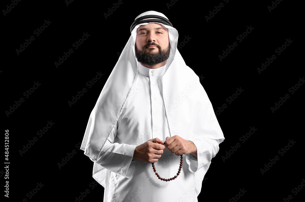 Wall mural muslim man with prayer beads on black background