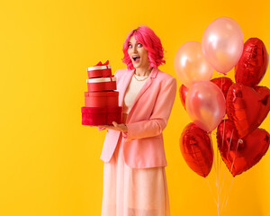 Surprised woman with bright hair, gifts and air balloons on color background. Valentine's Day celebration