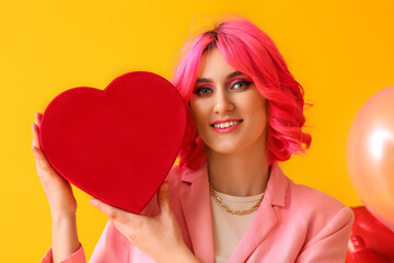 Obraz na płótnie Canvas Stylish woman with bright hair and gift on color background. Valentine's Day celebration