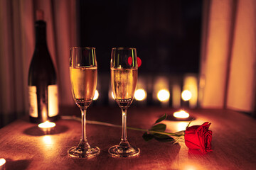 Valentines day date, romantic candle light and single red rose 
