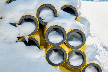 Gas pipes on a construction site under the snow.