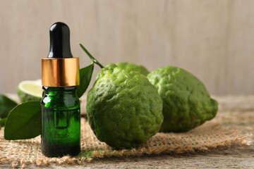 Bottle of essential oil and fresh bergamot fruits on table - obrazy, fototapety, plakaty