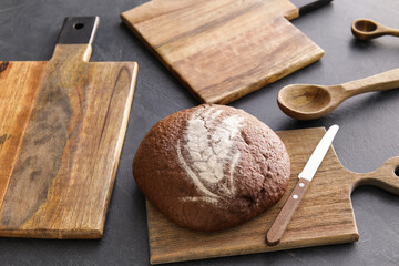 Wooden cutting boards and bread on black background