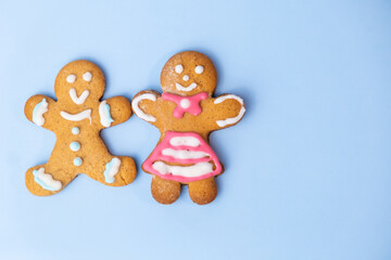 Boy and black girl gingerbread couplet on the blue background with copy space for St Valentines Day. 