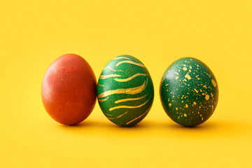 Stylish Easter eggs on yellow background