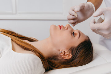 Doctor examining patient nose after rhinoplasty surgery, medical operation