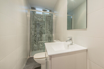 Bathroom decorated in a contemporary style with a shower wall covered with hydraulic tiles, a white vanity unit and a frameless glass mirror