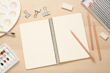 Flat lay composition with blank sketchbook on wooden table. Space for text