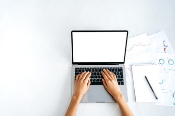 Laptop with white blank screen, mockup for announcement, advertising. Top view, female hands lie on a laptop keyboard with a blank white screen, a girl typing text,browsing information on the Internet