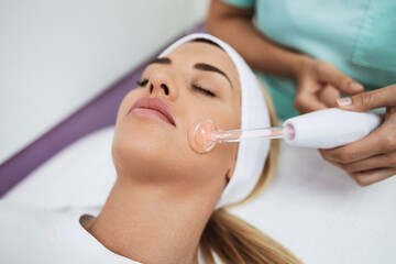 Beautiful young female patient receiving modern medical and beauty pore control treatment with no...