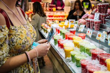 Woman standing at counter with refreshing fruit drinks