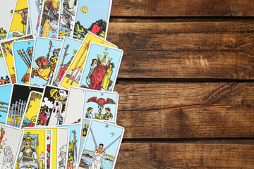 Tarot cards on wooden table, top view. Space for text