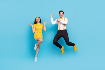 Fototapeta na wymiar Full length portrait of excited active partners raise hands fists flight isolated on blue color background