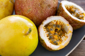 Naklejka na ściany i meble Exotic passion fruit on plate, tropical food
