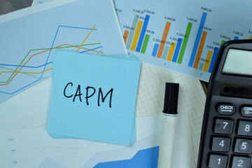 CAPM write on sticky notes isolated on Wooden Table.