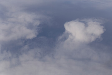 Stratosphere, a view of clouds from an airplane window.  Cumuliform cloudscape on sky. Flying over the land.