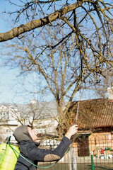 Fumigating pesti, pest control. Defocus farmer man spraying tree with manual pesticide sprayer...