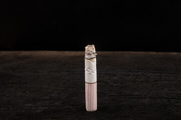 burning cigarette on black background close-up, smoking addiction bad habit
