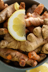 Turmeric and ginger roots with lemon in bowl