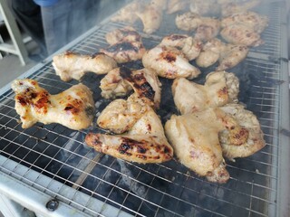 Close up photo of chicken wing meat on grill.