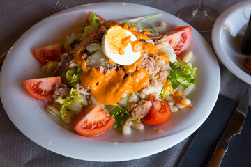 Traditional Catalan salad Xatonada with curled endive, tuna, cod and vegetables