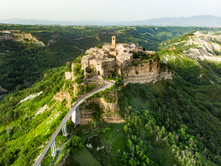 Fototapeta na wymiar Aerial summer evening view of famous Civita di Bagnoregio town, beautiful place located on top of a volcanic tuff hill overlooking the Tiber river valley
