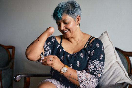 Woman with one hand applying nail polish at home