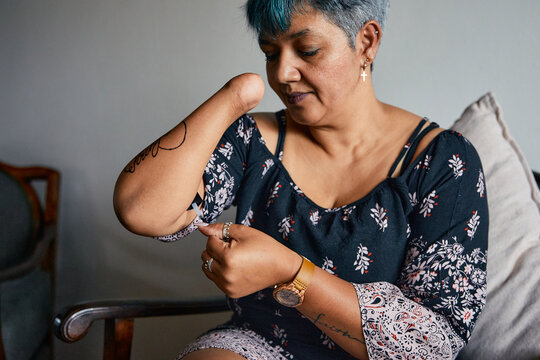 Woman with one hand applying nail polish at home