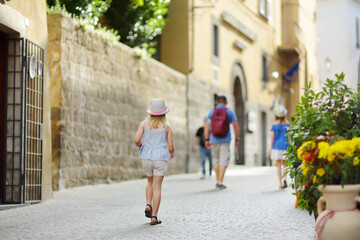 Father and daughters exploring the famous Orvieto, a medieval hill town, rising above the...