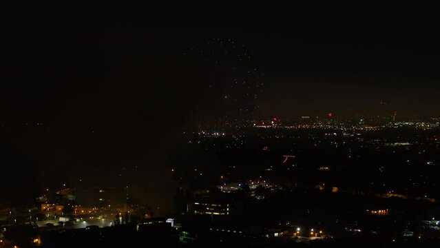 Aerial Lockdown Shot Of Fireworks Exploding In Illuminated City At Night - Los Angeles, California