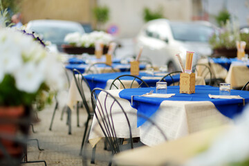 Outdoor restaurant table in of the famous Pitigliano town, located atop a volcanic tufa ridge. Beautiful italian towns and villages. Etruscan heritage, Tuscany, Italy.