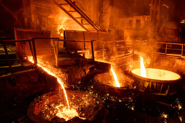 Blast furnace slag and pig iron tapping. Molten metal and slag are poured into a ladle.